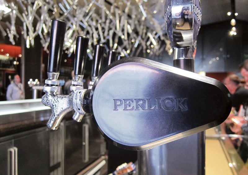 Close up of Perlick tap dispenser. Side of silver dispenser says Perlick engraved on it.